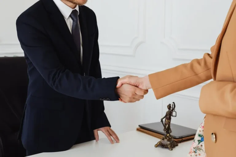 Ein Anwalt für Arbeitsrecht in Offenbach begrüßt eine Mandantin mit einem Handschlag, der Vertrauen und eine gute Zusammenarbeit signalisiert.